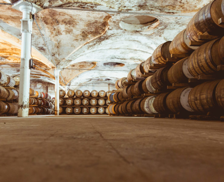 Old vintage whisky barrels filled of whiskey placed in order in